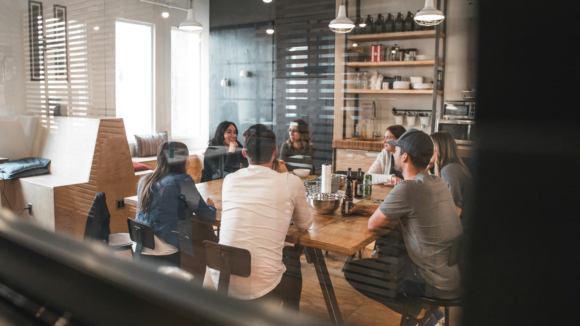 A team of colleagues gathered round a wooden table in relaxed conversation