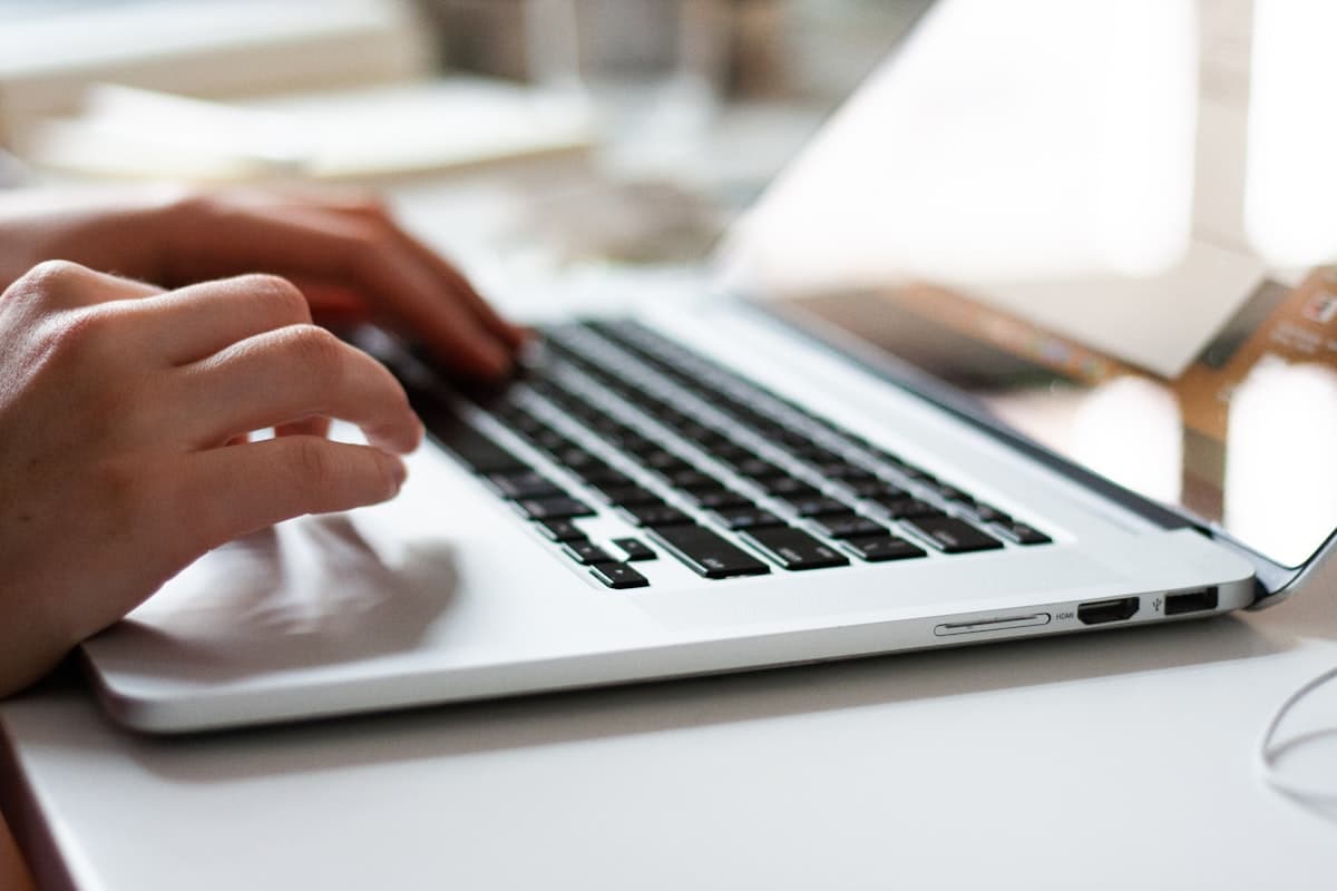 Close-up of someone typing on a laptop