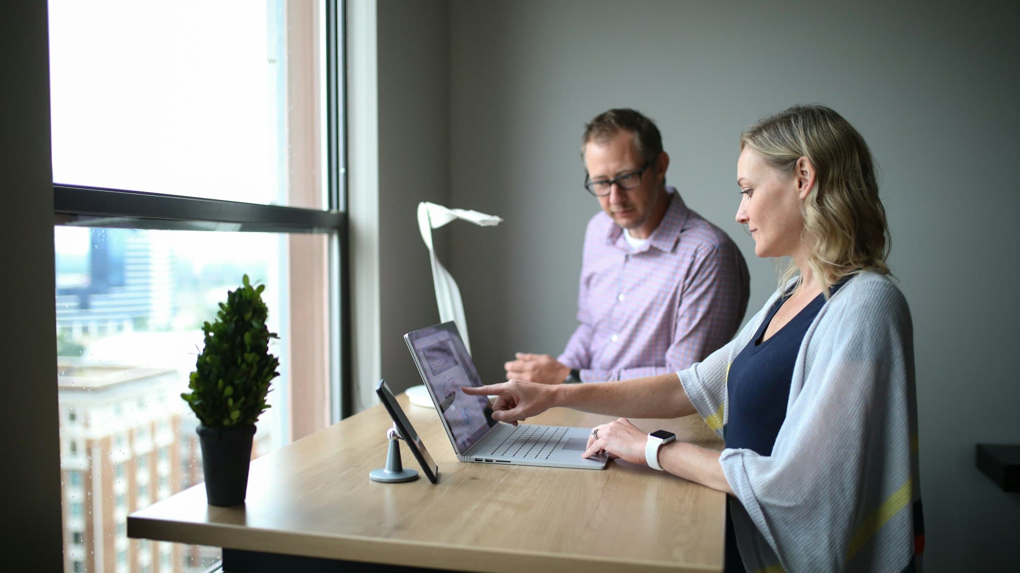 A man and woman working through a problem together at a laptop
